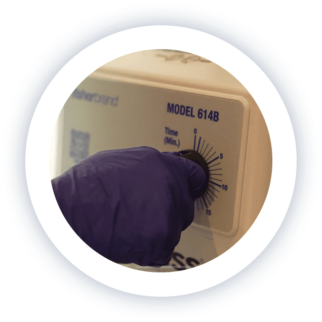 Gloved medical staff member operating lab equipment at Lite Medical Clinic as part of sterile medication preparation.